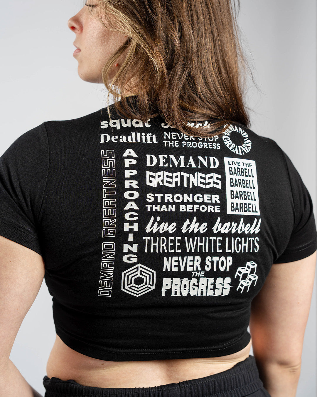 Back view of A7 Affirmation True-Fit Women's Crop – Domino showcasing motivational mantras in white text on black fabric.