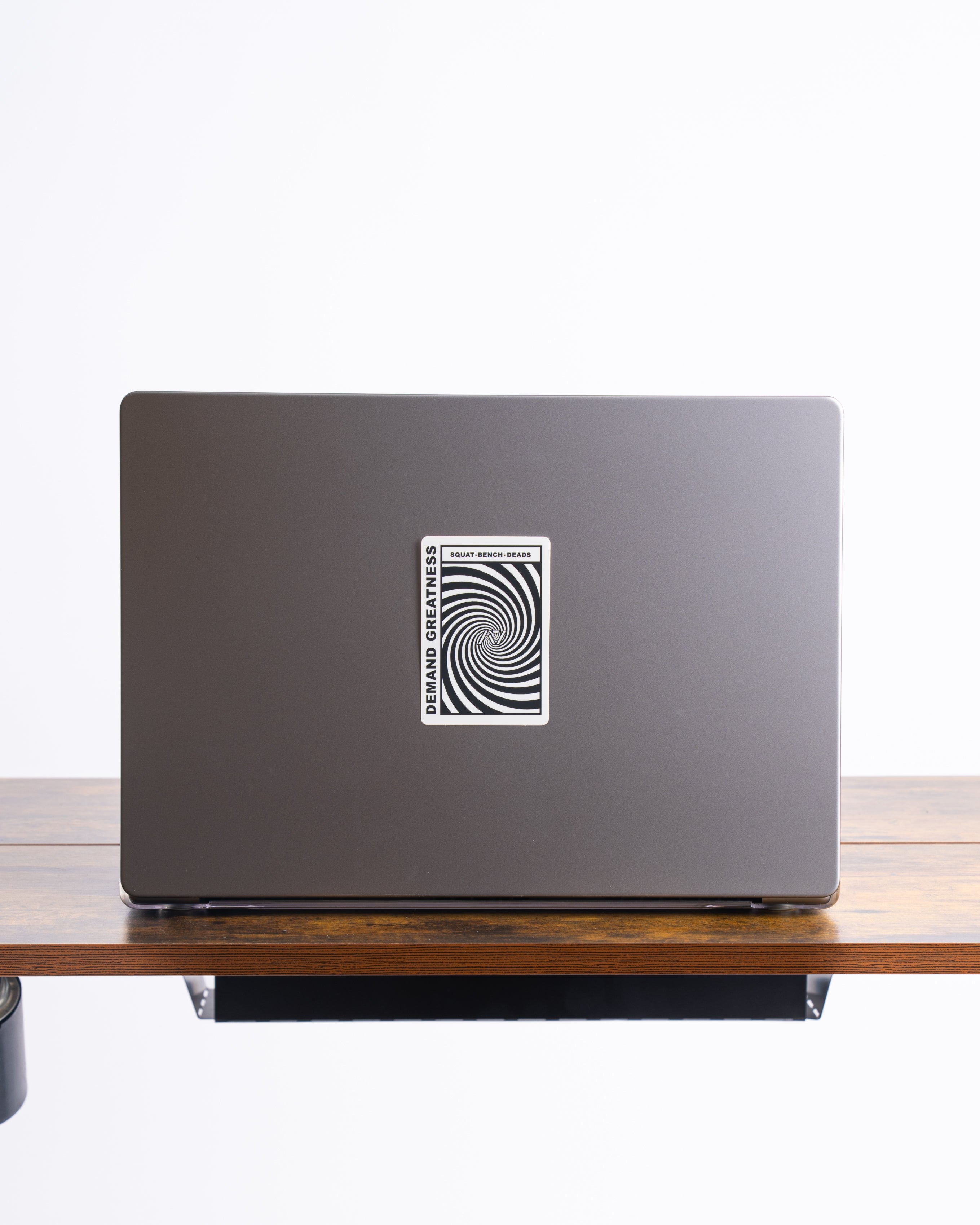A7 Helix sticker on a laptop cover beside gym accessories, styled in an athletic environment.