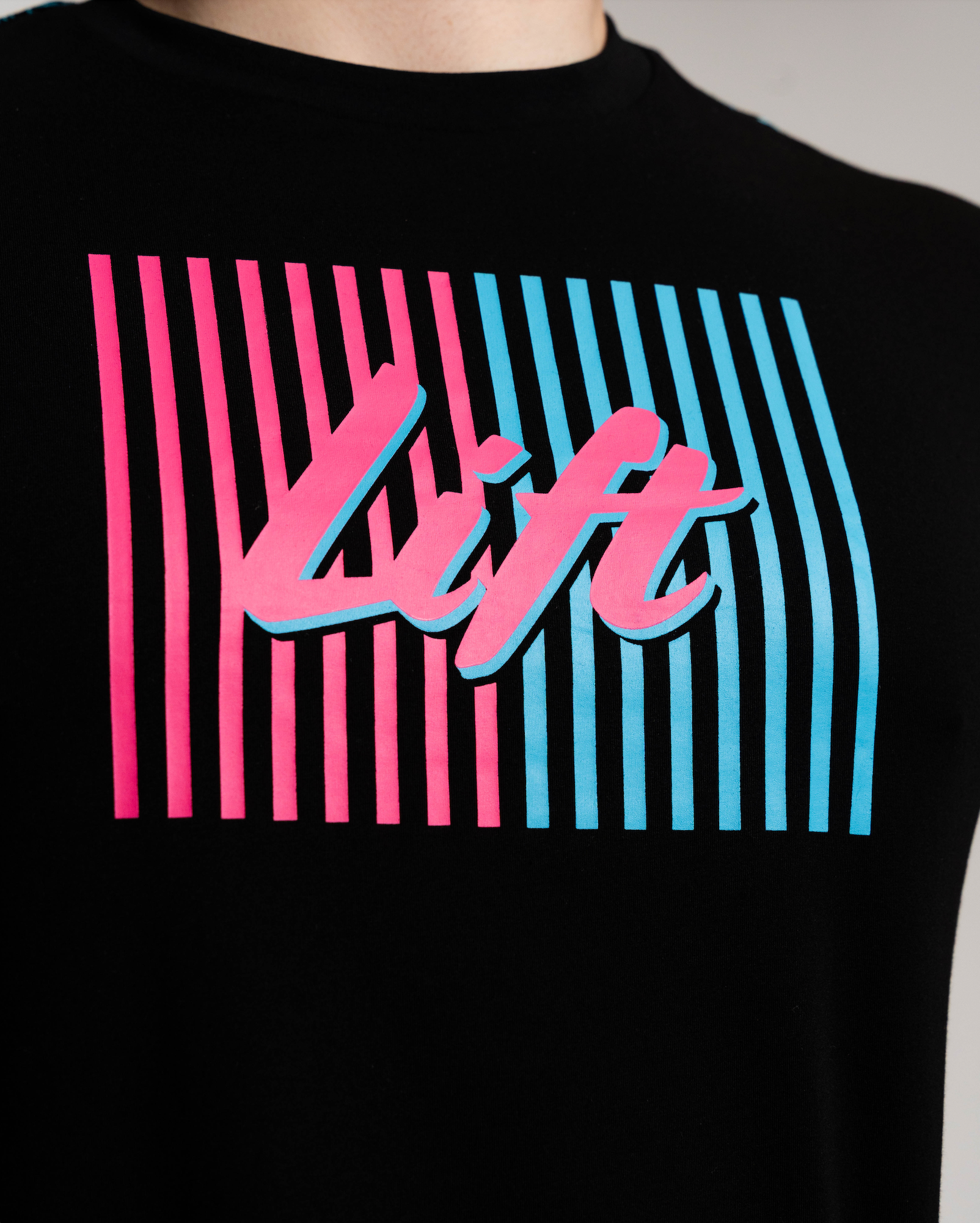 Black t-shirt with pink and blue striped design and 'lift' text on a plain background