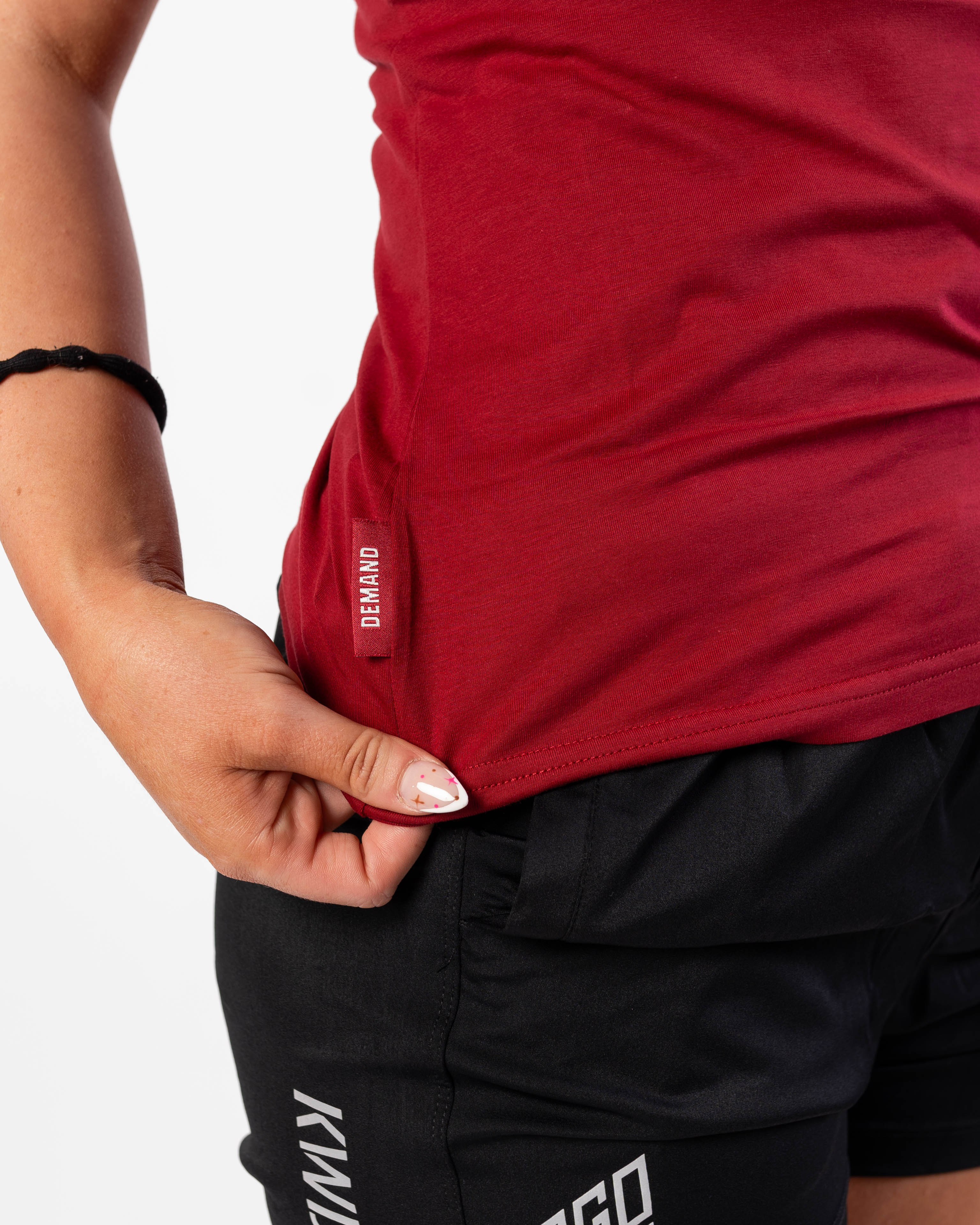 Side Hem Tag on Women's Meet Shirt with Demand Greatness text on the hem tag