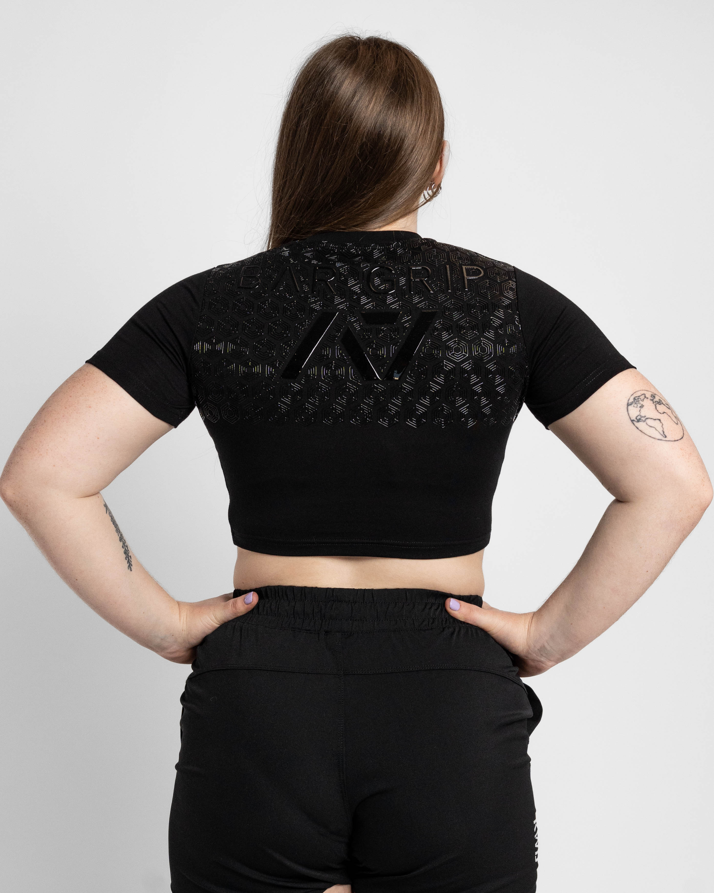 Person wearing a black crop top with bar grip