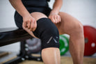 Athlete with A7 Stealth Stiff CONE Knee Sleeve on, displaying fit, A7 logo and double-stitched seams.